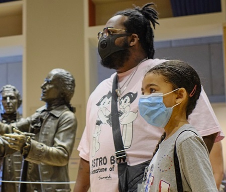 Adult and child wearing masks in Signers Hall