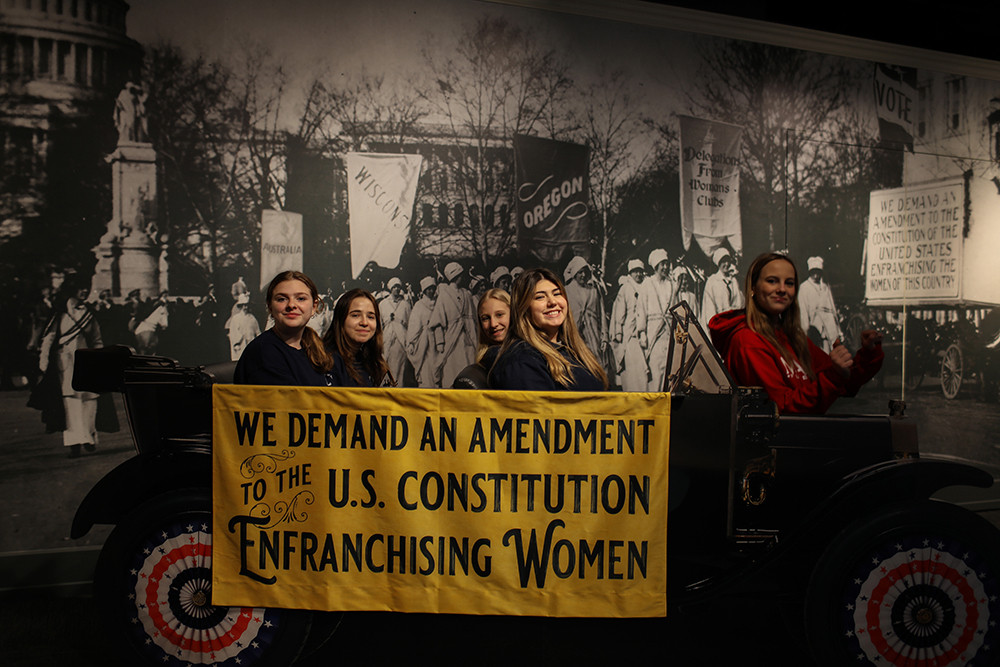 Students positing for a photo in the 19th Amendment Exhibit