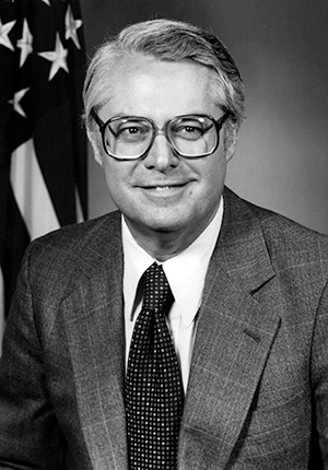 A. Ernest Fitzgerald head-and-shoulders portrait, seated in front of U.S. flag created by the United States Air Force.