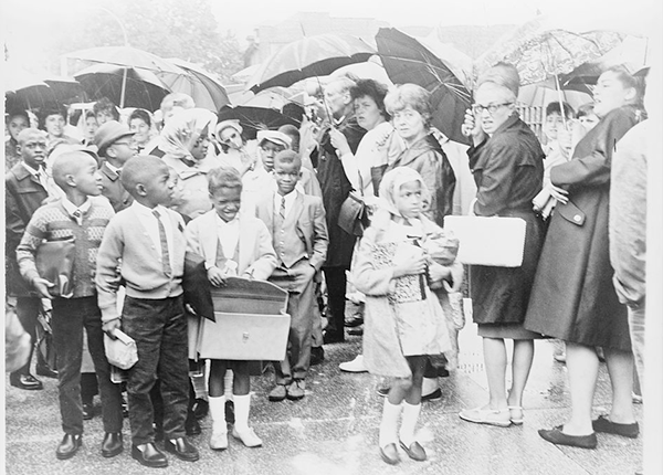 African American children on way to PS204, 82nd Street and 15th Avenue, past mothers protesting the busing of children to achieve integration.